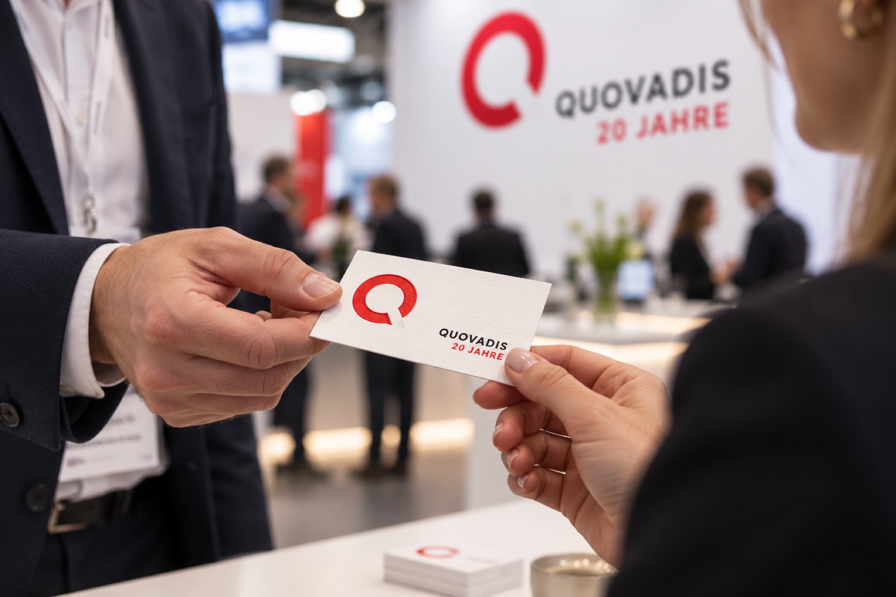Quovadis: Übergabe einer Visitenkarte auf einer Messe